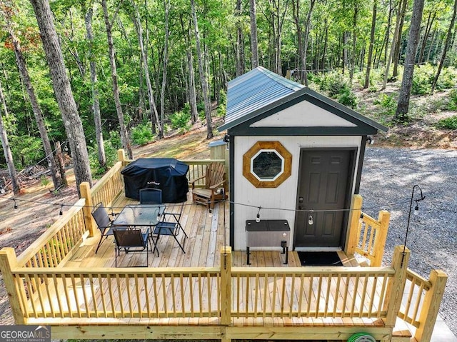 wooden terrace with a hot tub and grilling area