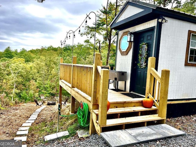 exterior space with an outdoor fire pit and a wooden deck