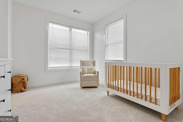 carpeted bedroom with multiple windows and a nursery area