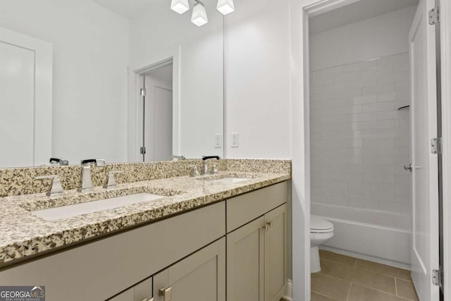 full bathroom with toilet, tiled shower / bath, tile patterned flooring, and vanity