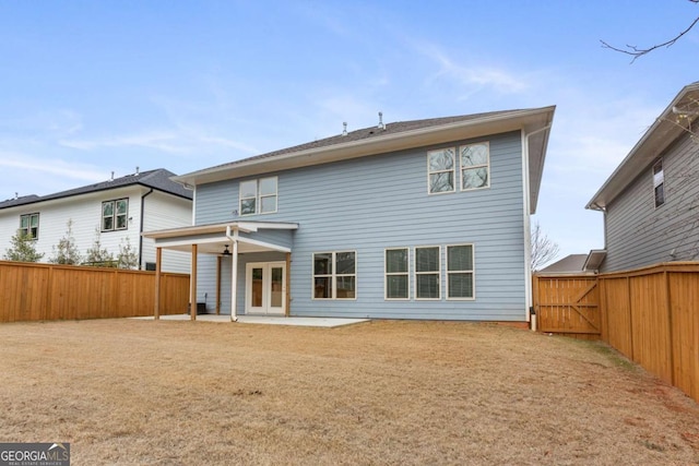 rear view of house featuring a lawn and a patio