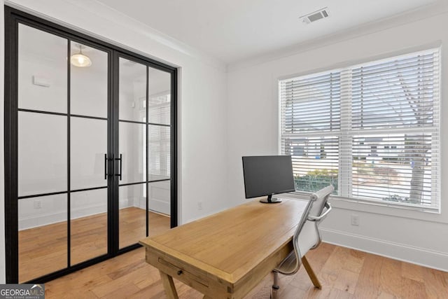 home office featuring ornamental molding and light hardwood / wood-style floors