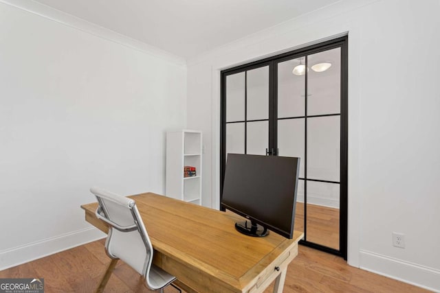 home office with crown molding and light wood-type flooring