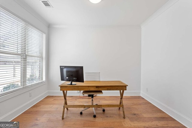 office with light hardwood / wood-style flooring and crown molding