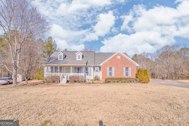 cape cod house with a front yard and a porch