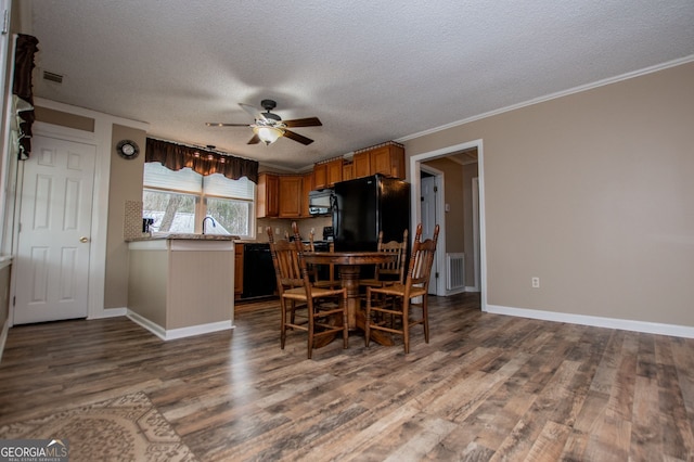 dining room with a textured ceiling, wood-type flooring, sink, ornamental molding, and ceiling fan