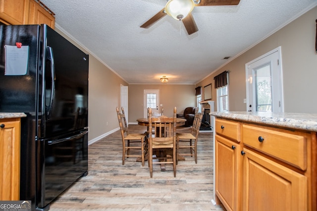 dining space with crown molding, light hardwood / wood-style floors, a textured ceiling, and ceiling fan