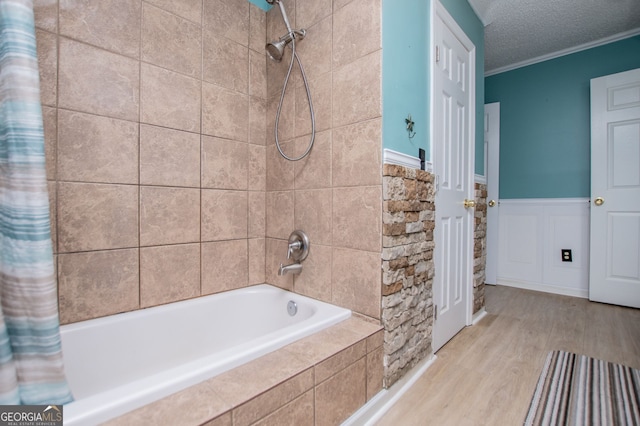 bathroom featuring ornamental molding, hardwood / wood-style flooring, a textured ceiling, and shower / tub combo with curtain