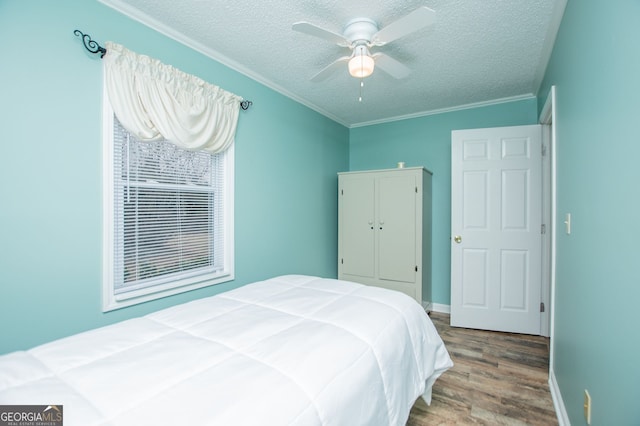 bedroom featuring crown molding, hardwood / wood-style floors, a textured ceiling, and ceiling fan