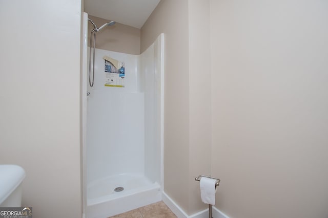 bathroom with a shower and tile patterned flooring