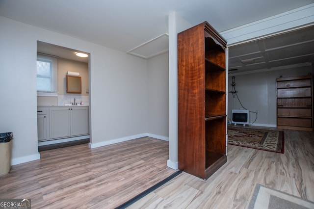 interior space with sink, heating unit, and light hardwood / wood-style floors