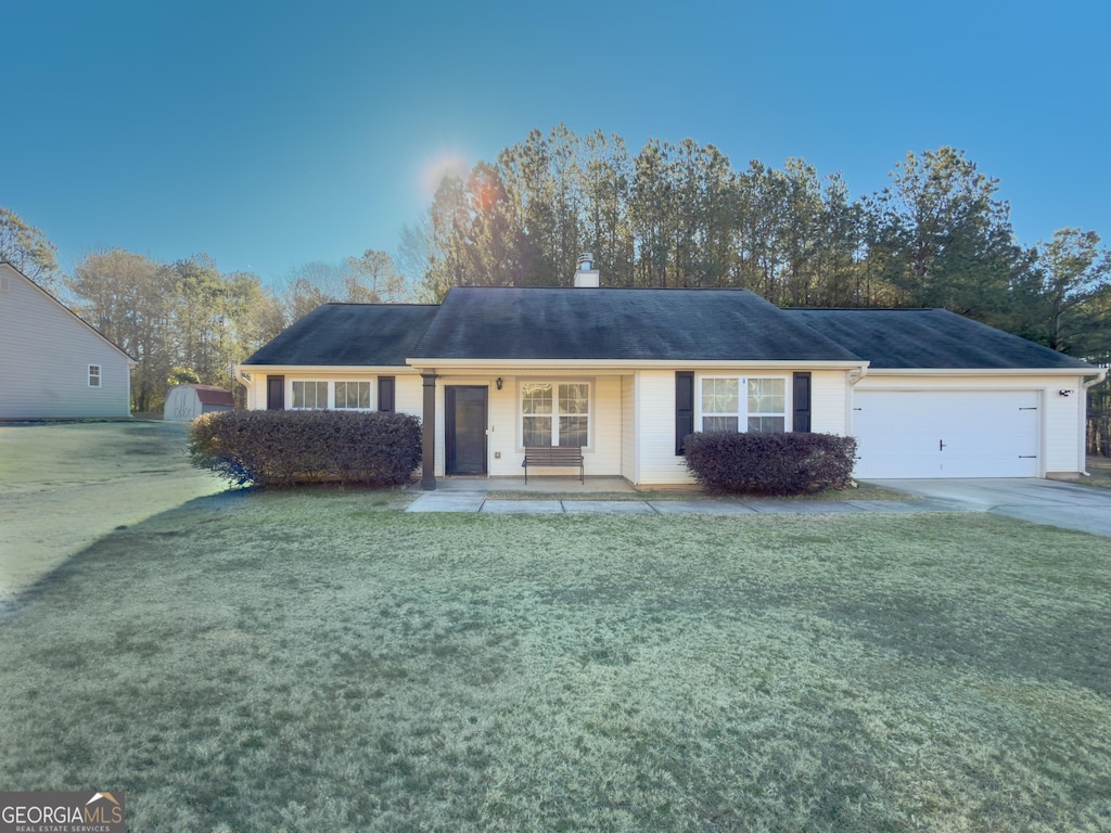 ranch-style home with a garage and a front lawn