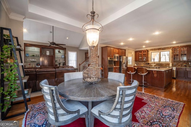 dining room featuring dark wood-type flooring, vaulted ceiling, and ceiling fan