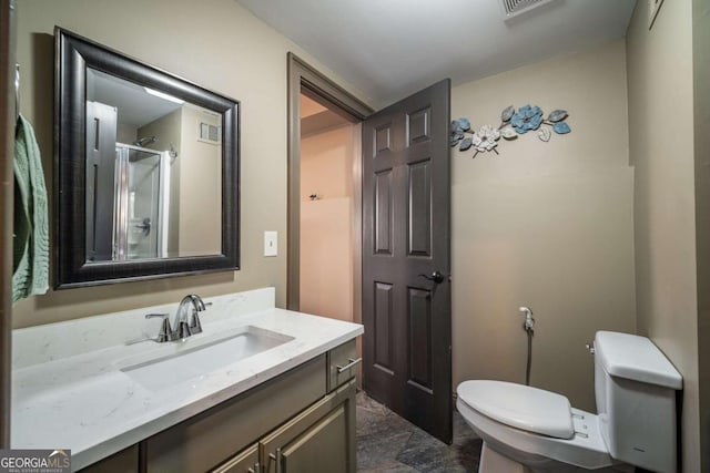 bathroom featuring an enclosed shower, vanity, and toilet