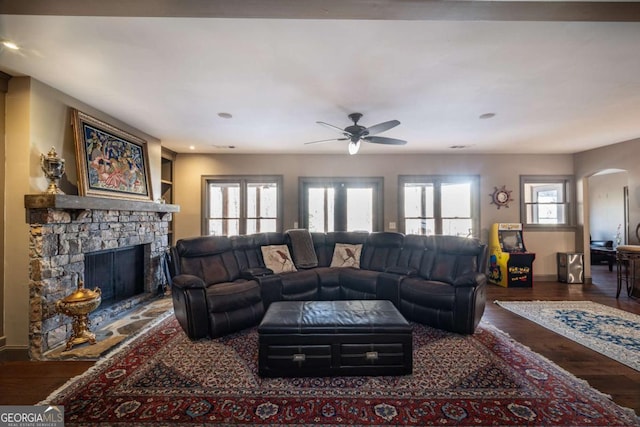 living room featuring built in shelves, a fireplace, and dark hardwood / wood-style flooring