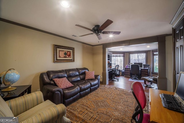 living room with hardwood / wood-style flooring, ceiling fan, and ornamental molding