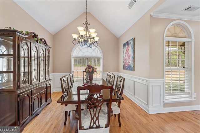 dining space with a notable chandelier, light wood-type flooring, and plenty of natural light