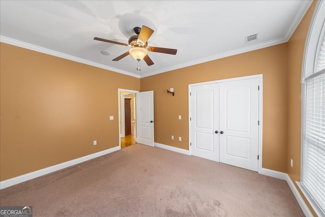 unfurnished bedroom with light colored carpet, a closet, ceiling fan, and ornamental molding