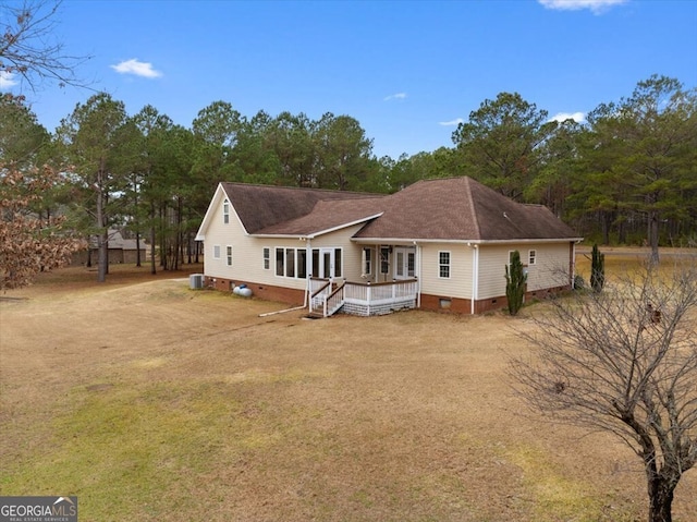 back of house featuring central AC, a wooden deck, and a yard