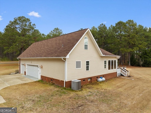 view of side of property featuring a yard, central AC, and a garage