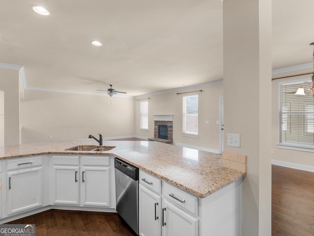 kitchen featuring dishwasher, open floor plan, a sink, and light stone countertops