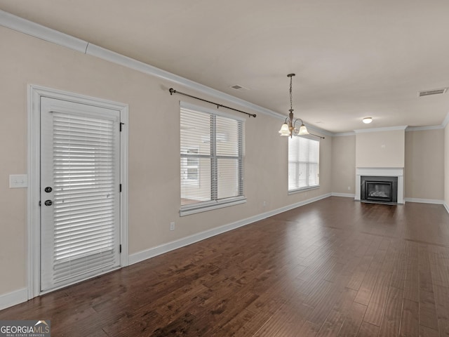 unfurnished living room with ornamental molding, a glass covered fireplace, dark wood-style flooring, and visible vents