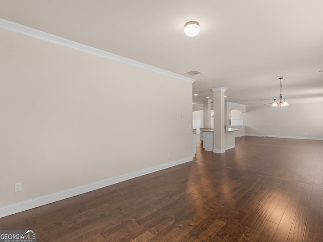 unfurnished living room with baseboards, visible vents, dark wood finished floors, and ornamental molding