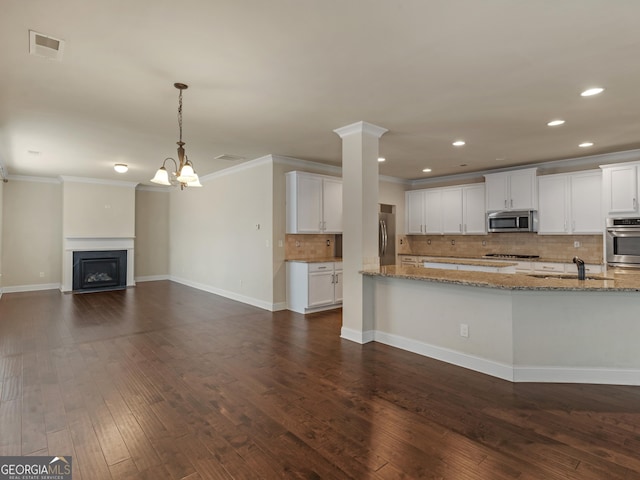 kitchen featuring visible vents, appliances with stainless steel finishes, light stone countertops, white cabinetry, and pendant lighting