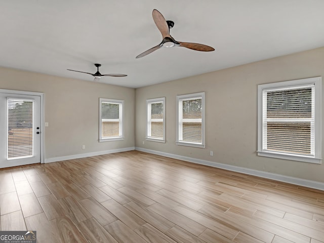 unfurnished room with light wood-type flooring, baseboards, and a ceiling fan