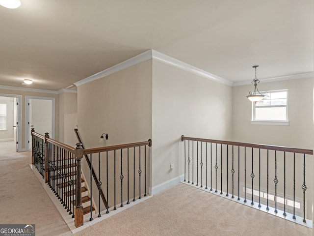 hallway featuring light carpet, baseboards, crown molding, and an upstairs landing