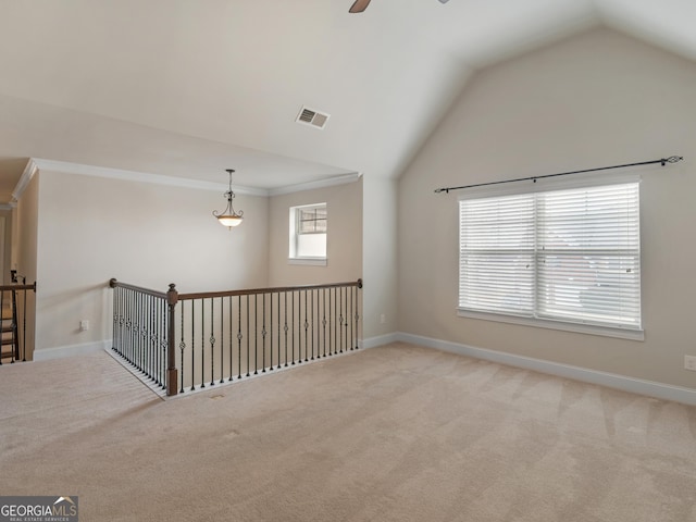 empty room featuring light carpet, baseboards, visible vents, a ceiling fan, and lofted ceiling