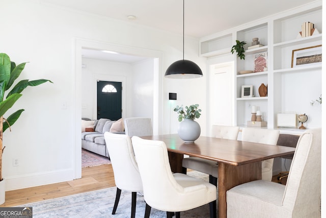 dining space with hardwood / wood-style flooring and crown molding