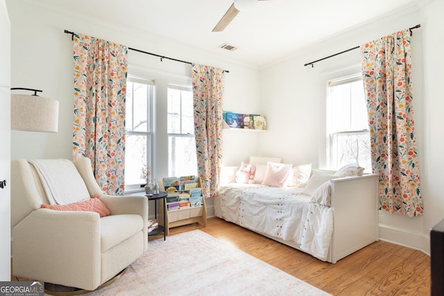 bedroom featuring multiple windows, wood-type flooring, and ceiling fan