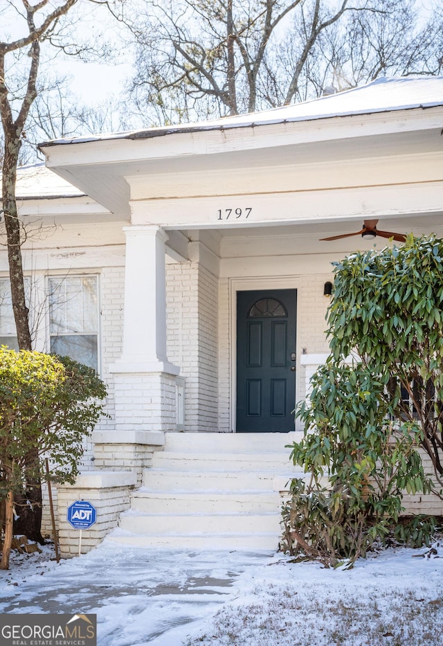 snow covered property entrance featuring a porch