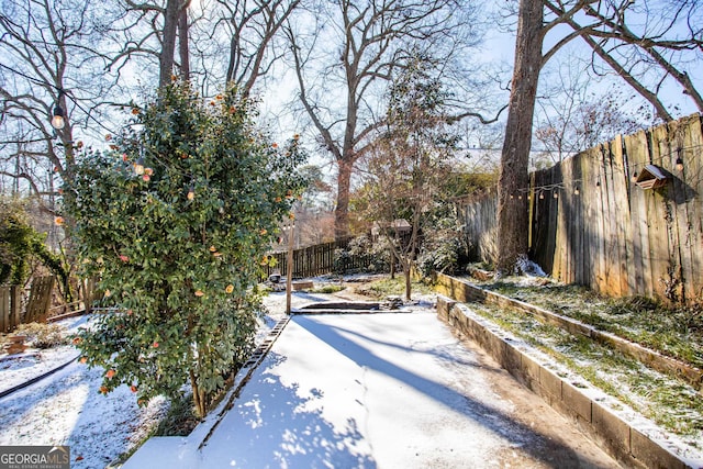 yard covered in snow featuring a patio