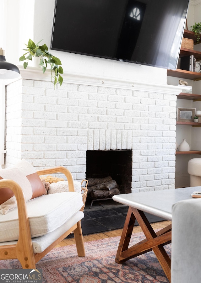 living room with hardwood / wood-style flooring and a brick fireplace