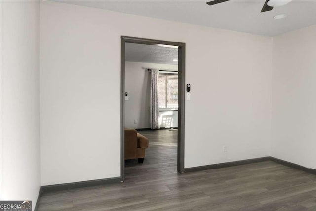 spare room featuring ceiling fan and dark hardwood / wood-style flooring