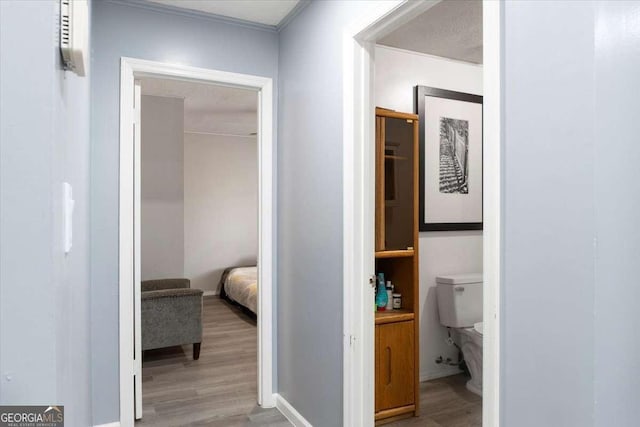 corridor with light hardwood / wood-style floors and a textured ceiling