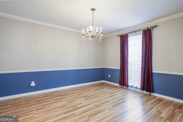 spare room featuring crown molding, light hardwood / wood-style flooring, and a notable chandelier