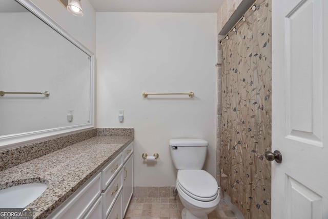 bathroom featuring a shower with curtain, vanity, and toilet