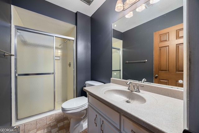 bathroom featuring vanity, a shower with shower door, and toilet