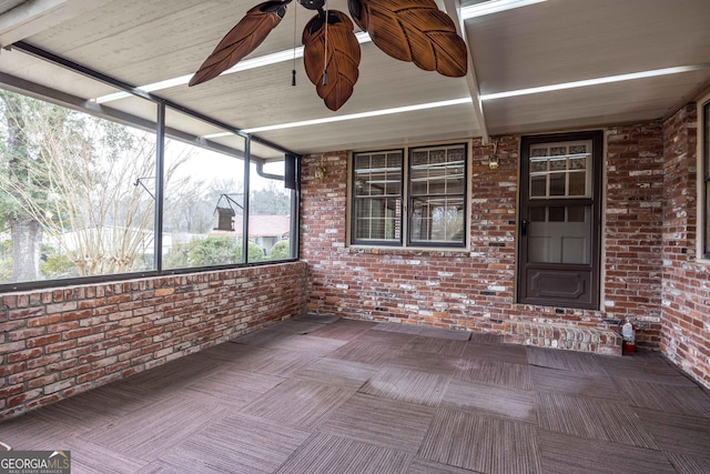 unfurnished sunroom with ceiling fan