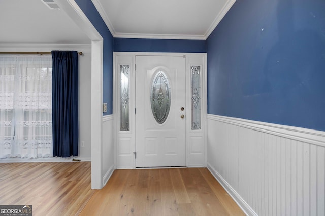 entrance foyer featuring ornamental molding and light hardwood / wood-style floors