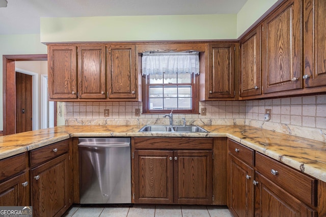 kitchen featuring light tile patterned flooring, sink, backsplash, stainless steel dishwasher, and light stone countertops