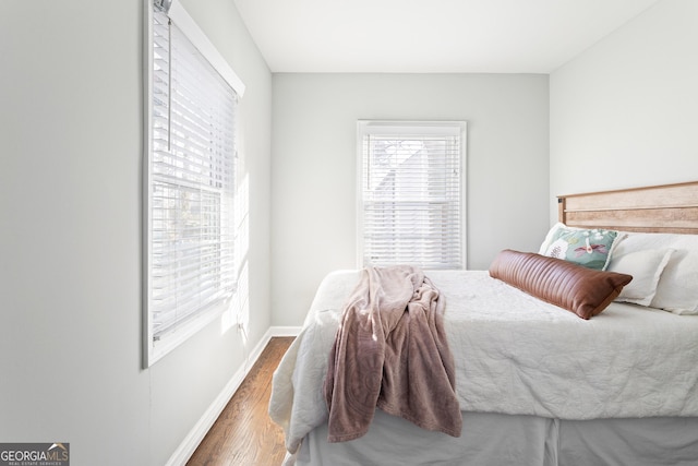 bedroom with dark hardwood / wood-style flooring