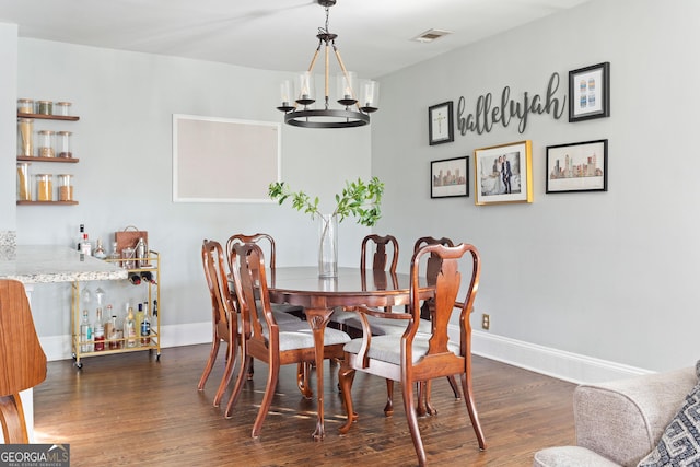 dining space with an inviting chandelier and dark wood-type flooring