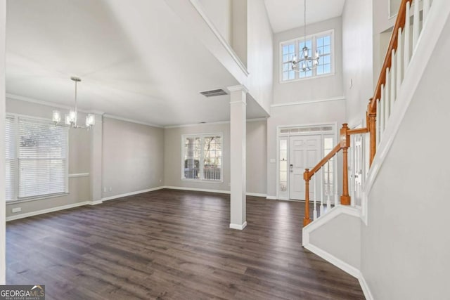 foyer entrance with a notable chandelier, a wealth of natural light, and dark hardwood / wood-style flooring