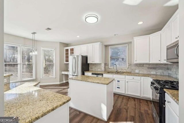 kitchen featuring pendant lighting, a center island, white cabinetry, and appliances with stainless steel finishes