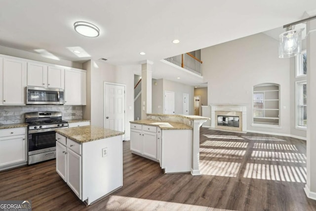 kitchen with white cabinets, stainless steel appliances, and a kitchen island