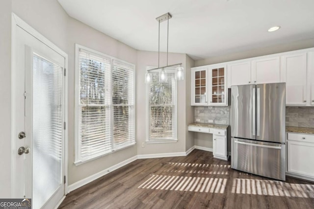 kitchen with white cabinets, backsplash, and stainless steel refrigerator